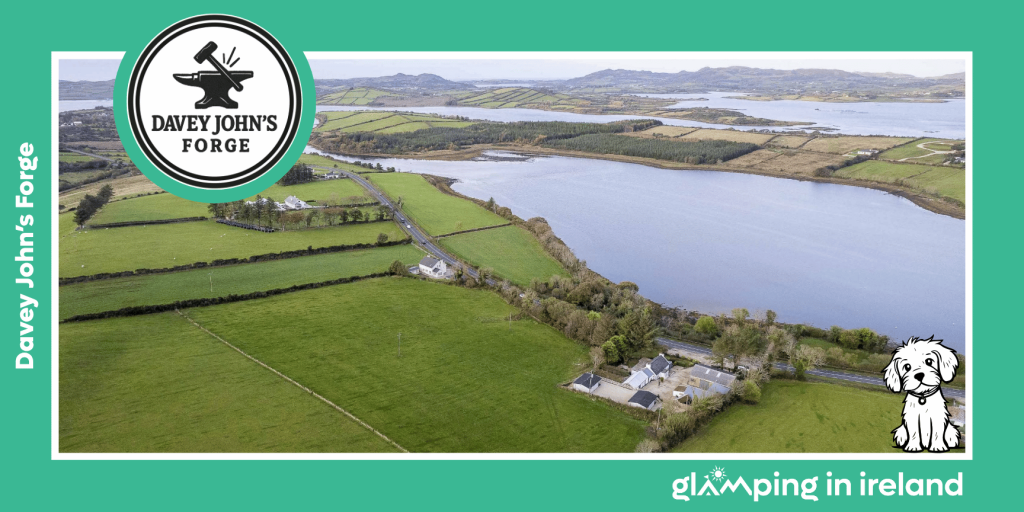 Image shows an aerial view of Davey John’s Forge, a glampsite in County DOnegal, with a rural location and Mulroy Bay in the background/