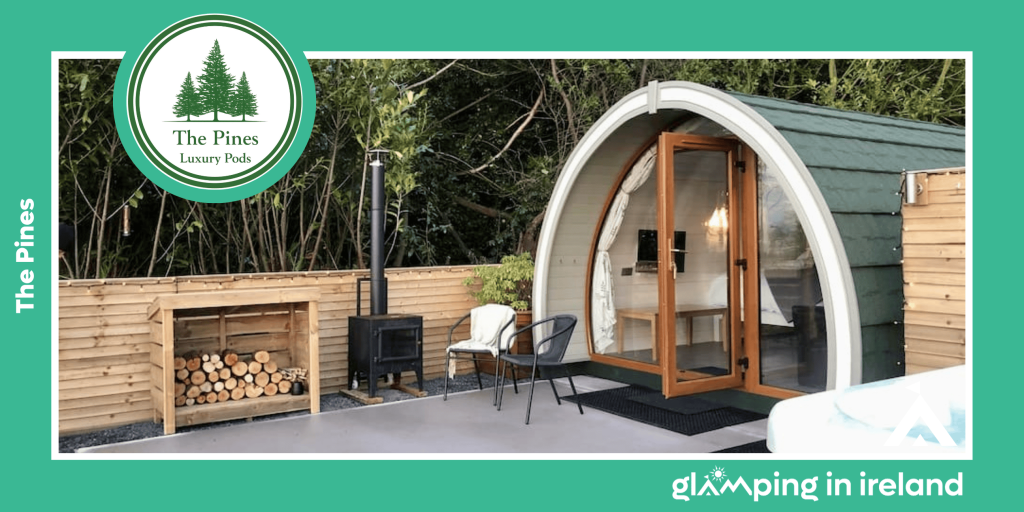 image of a glamping pod, with outdoor stove with a stack of firewood